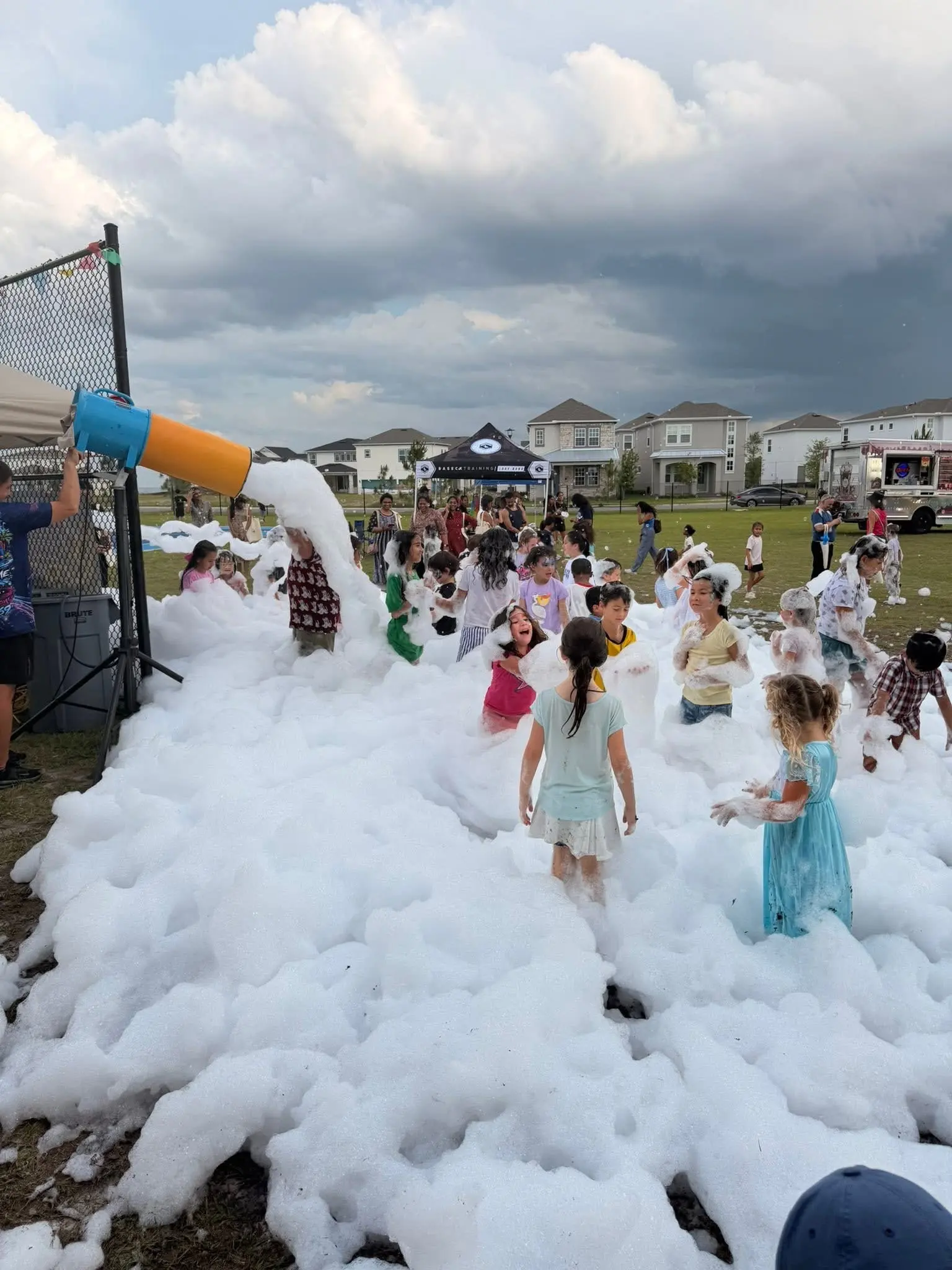 Neighborhood community foam party with families playing in deep foam